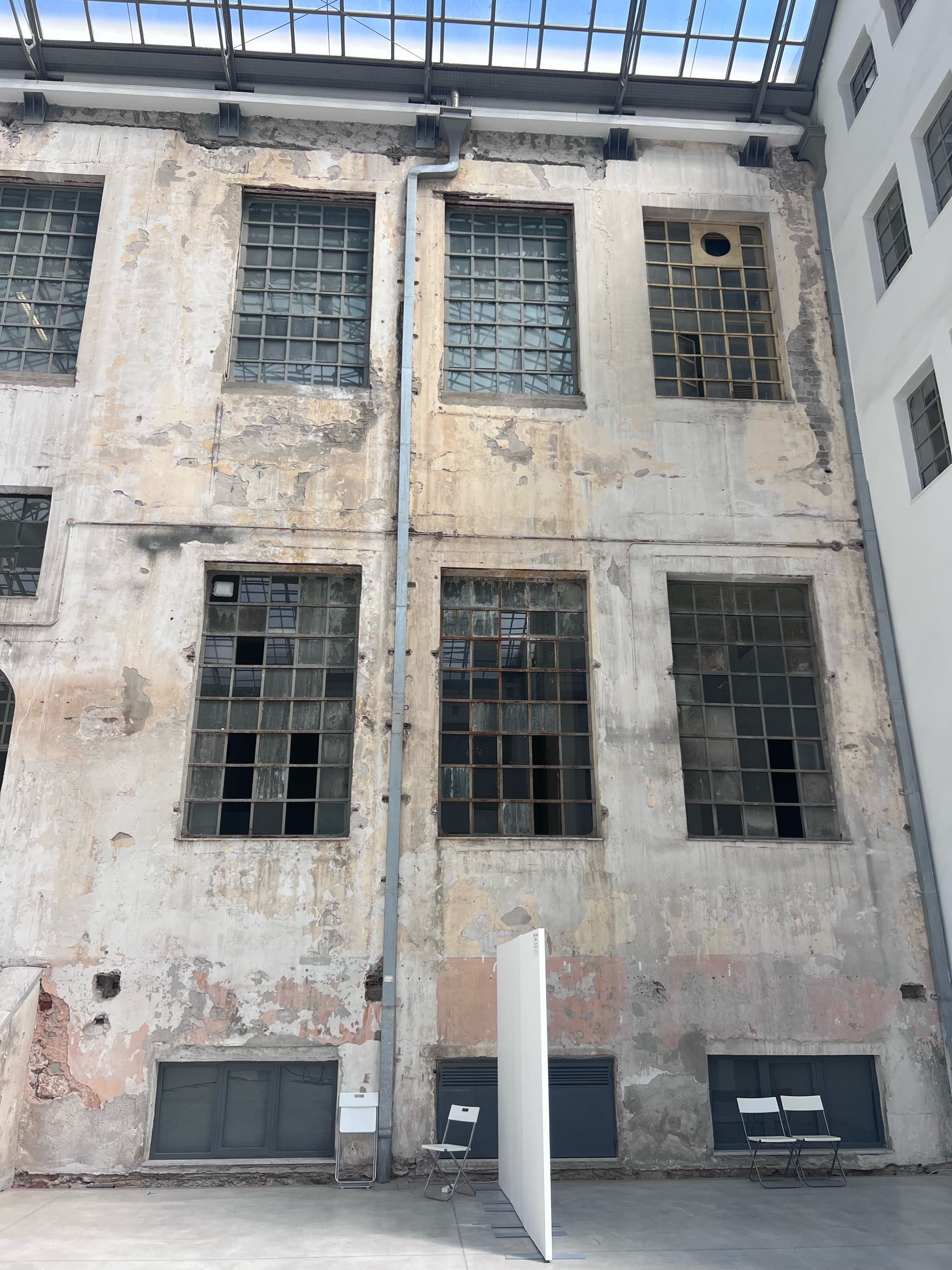 The weathered inner façade of the Tobacco Factory, tall steel windows under the glass roof