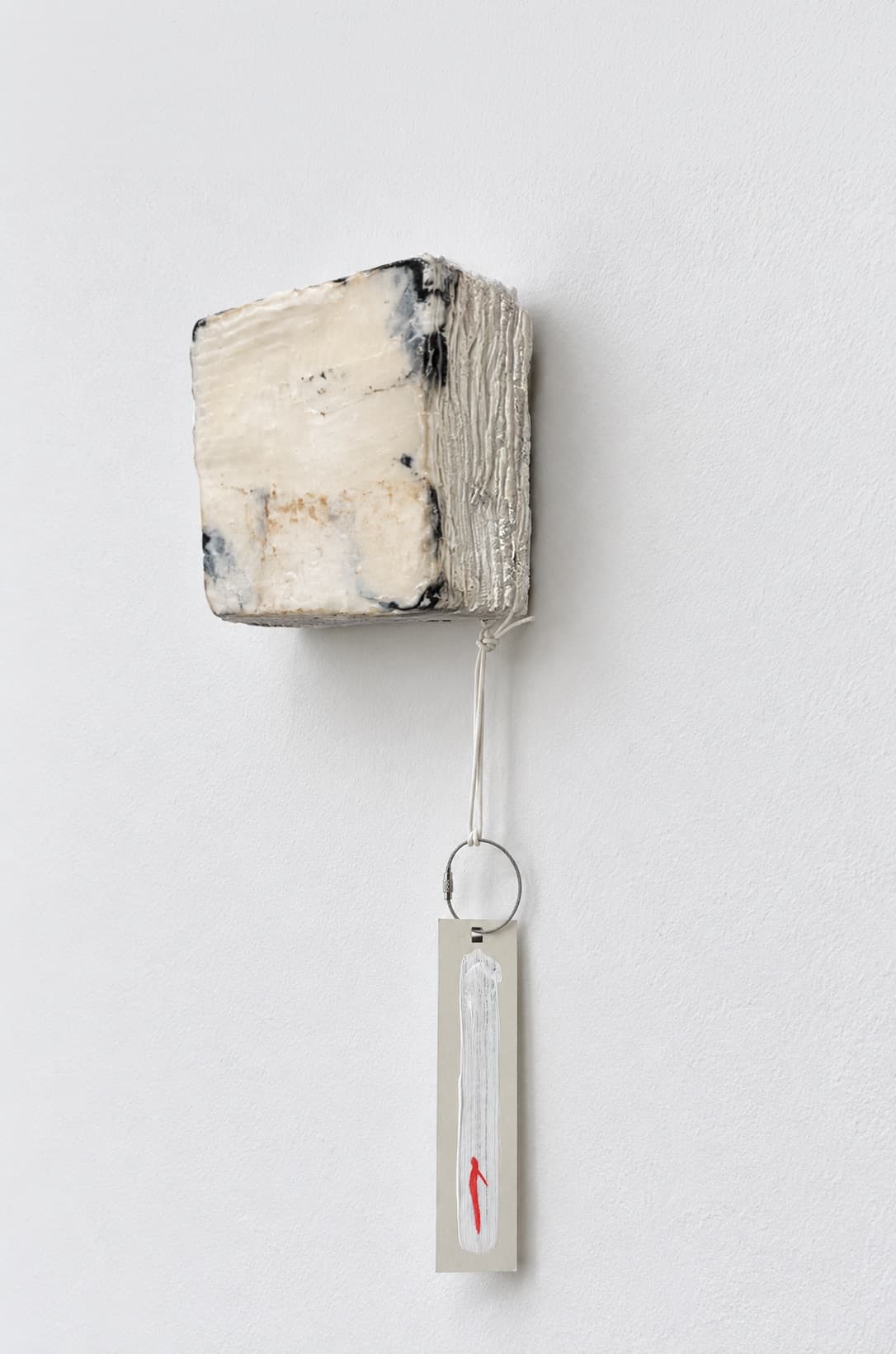 The same object seen from an angle, the tag turning on its ribbon below it