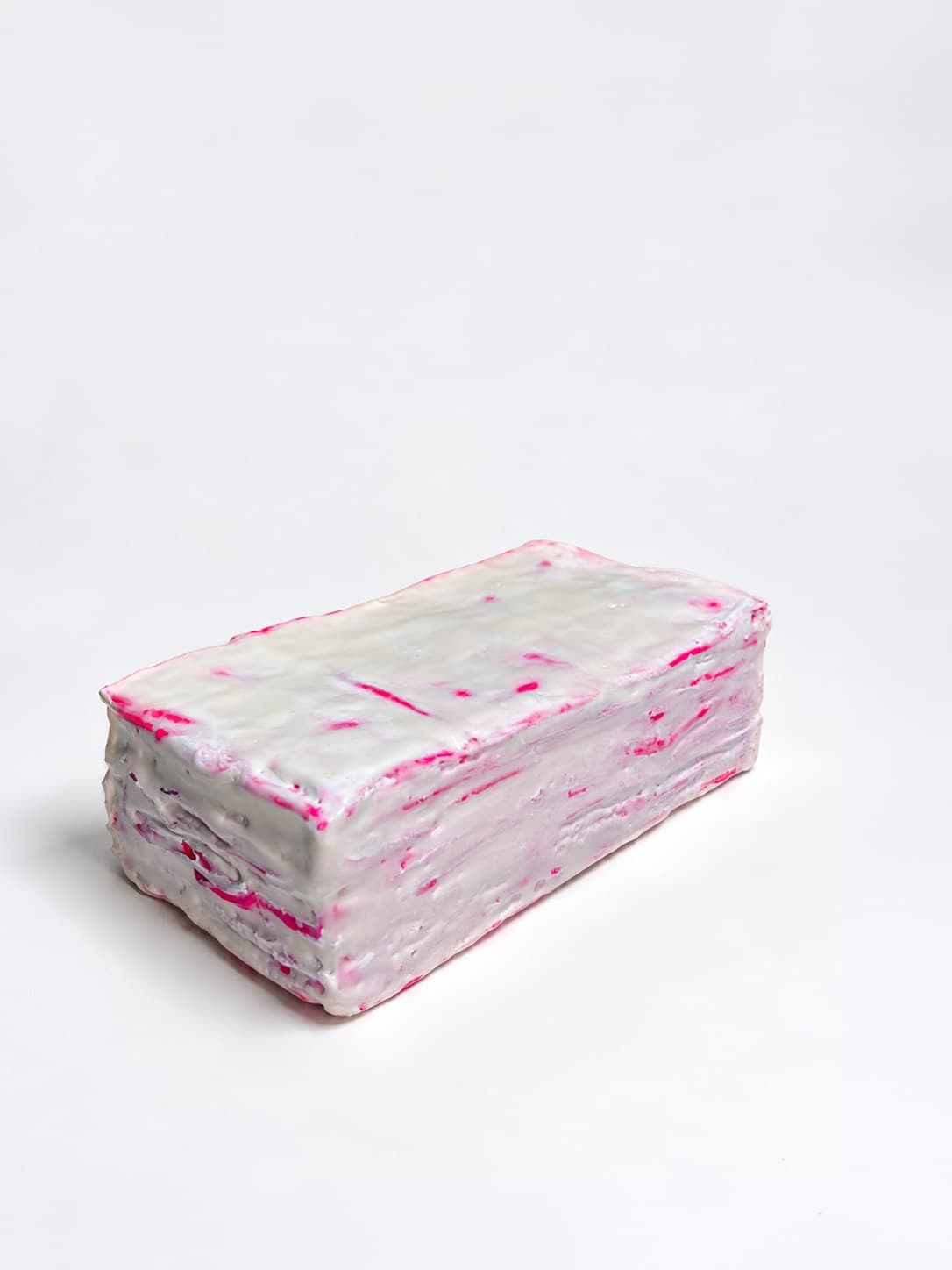 The object lying on its side, the layers of cloth visible along the waxed edge