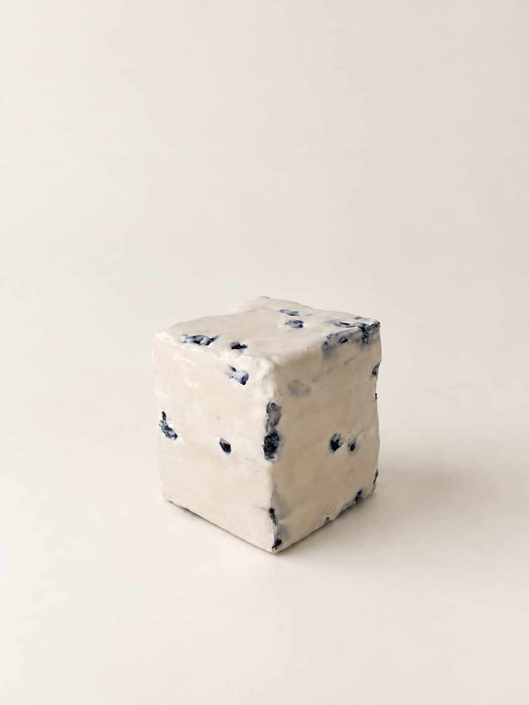 The cube turned on its corner, the blue flecks running down one face