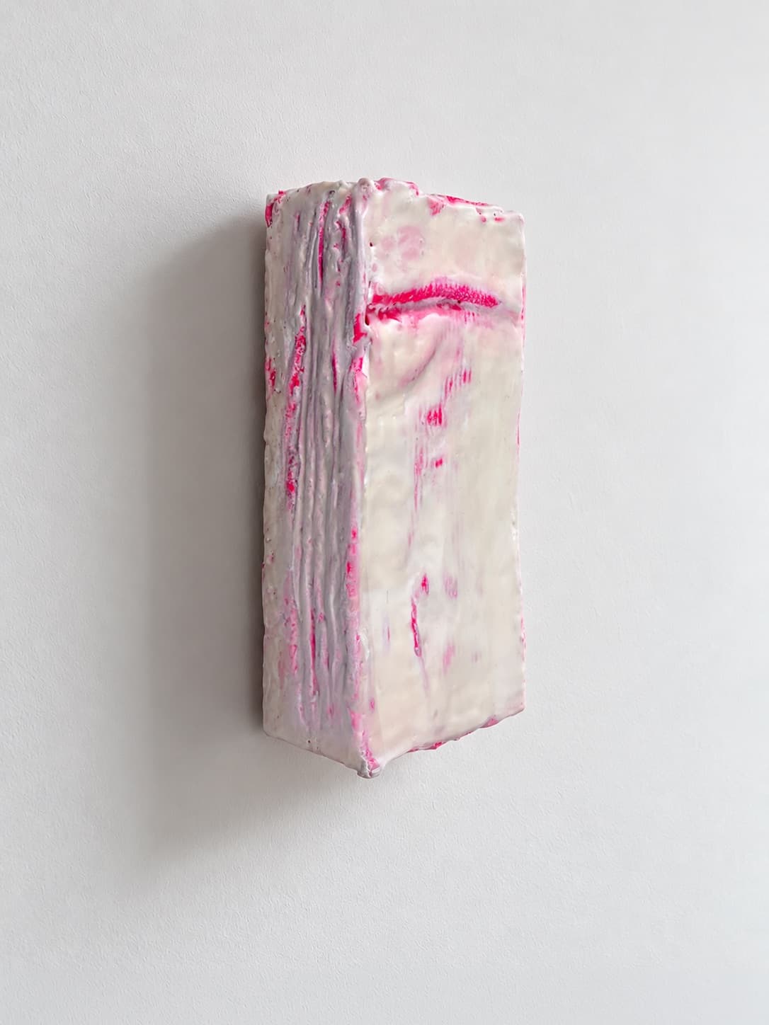 The object seen from the side, pink ridges running down the waxed edge