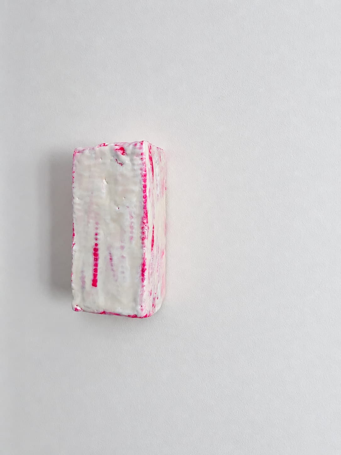 The object seen from the other side, pink dripping down the waxed face