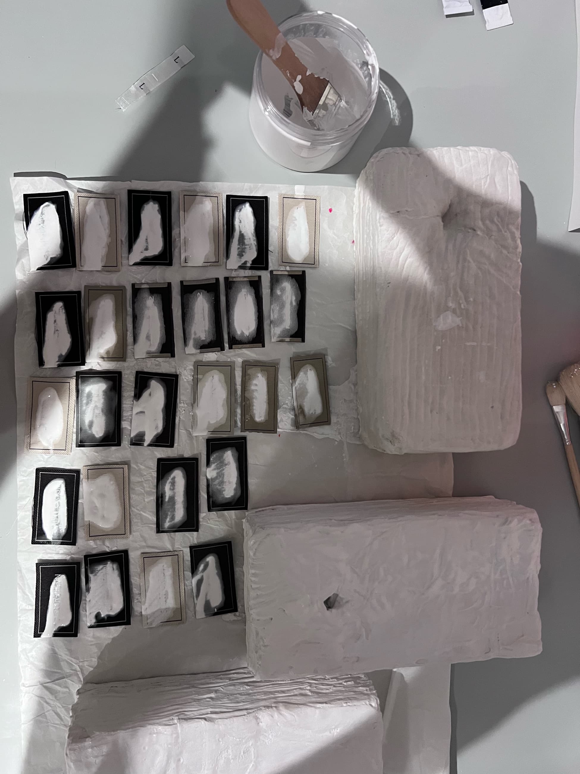 Rows of small black-and-white tags laid out beside pale rough bricks